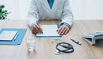 Professional doctor in his office working at desk and writing a medical report, healthcare and hospitals concept