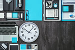 Corporate business desktop with laptop, office accessories and a clock: business productivity and deadlines concept