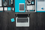 Flat lay corporate business desktop with office accessories and a laptop on a dark background