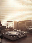Vintage retro revival objects and appliances assortment on a table, turntable record player on the foreground