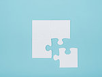 Blank jigsaw puzzle pieces on a light blue background, problem solving and challenge concept