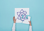 Woman completing a puzzle with atom icon, she is putting the missing piece, physics and science concept