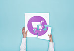 Woman completing a puzzle with a shopping cart icon, she is putting the missing piece, shopping and retail concept