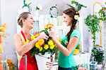 Florist woman and customer in flower shop discussing the offerings