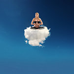 Pregnant young woman doing yoga on a soft cloud