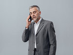 Confident businessman having a phone call with his smartphone