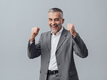 Cheerful successful businessman with fists raised, satisfaction and achievement concept