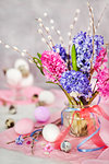 Easter eggs with beautiful hyacinths and willow bouquet on light background, spring holiday concept