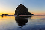 Beachcombers by Haystack Rock at Cannon Beach Oregon Coast low tide at sunset