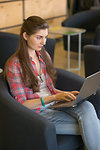 Portrait of a Serious Woman Working on Laptop in the Chair Indoors.