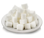 Cubes of white sugar in a white saucer on a white background