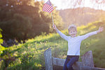 positive little boy with american flag celebrating 4th of july, independence day, or memorial day