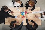 Teamwork of businesspeople work together and combine pieces of gears. Partnership and integration concept