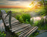 Old bridge through river at sunrise in summer