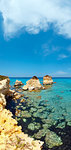 Picturesque seascape with white rocky cliffs, sea bay, islets and faraglioni at beach Spiaggia della Punticeddha, Salento Adriatic sea coast, Puglia, Italy. Two shots stitch vertical image.