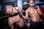 African American quick fighter punching in the chin his opponent during MMA fight