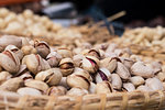 Background of basket of pistachios with shells, captured on street market, selective focus