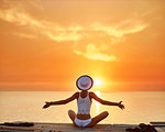 back view of a beautiful sexual woman in white hat and bikini sitting on the wooden pier on the beach against the sea and sky. happy woman enjoying summer vacation