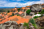 Large boulders on top on the montains side near the rooftops of the stone houses in the village of Monsanto in Idanha-a-Nova, Portugal