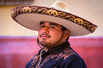 Close-up portrait of cowboy wearing sombrero on horseback, riding in parade to the Parroquia de San Miguel Arcangel in St Michael Archangel Festival, San Miguel de Allende, Mexico