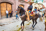 Cowboy riding dancing horse at parade to the Parroquia de San Miguel Arcangel in St Michael Archangel Festival, San Miguel de Allende, Mexico