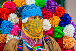 Close-up of indigenous tribal dancer wearing head scarves and colurful flowers at a St Michael Archangel Festival parade in San Miguel de Allende, Mexico