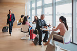 Business people working and talking in airport business lounge