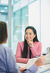 Smiling, attentive businesswoman listening to colleague in meeting