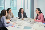 Smiling businesswomen talking in conference room meeting