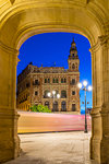 Light trails of the tram passing historical building at Plaza Nueva at dusk, Seville, Andalusia, Spain, Europe