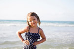 Cute girl on beach in spotted swimming costume, portrait, Castellammare del Golfo, Sicily, Italy