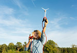 Teenage girl powering LED light using miniature wind turbine, Netherlands