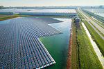 Floating solar panels installed on water supply of neighbouring greenhouses, elevated view, Netherlands