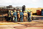 Firemen training, team of firemen listening to supervisor at training facility, rear view