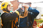 Firemen training, supervisor helping fireman with breathing apparatus at training facility