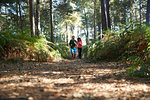 Male and female runners running in forest