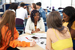 Female higher education students discussing project in college classroom