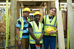Three male higher education carpentry students in college workshop, portrait