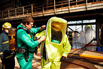 Firemen putting on fire proximity suit in training centre, Darlington, UK