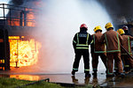 Firemen training to put out fire on burning building, Darlington, UK