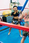 Male and female boxers working out in boxing ring