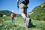 Hikers on lush green field, chalets in background, Mont Cervin, Matterhorn, Valais, Switzerland