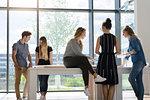 Colleagues brainstorming by glass wall