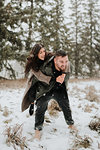 Couple playing piggyback in snowy landscape, Georgetown, Canada