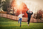 Siblings in halloween costume jumping in park