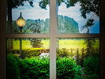 Classic cozy white window and a green forest view with a light in the shadows in a colorful landscape colorful