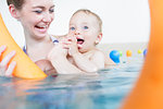 Mums being happy about their baby kids playing with each other in water