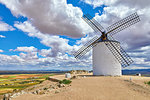 Wind mill at knolls at Consuegra, Toledo region, Castilla La Mancha, Spain. Route of Don Quixote with windmills. Summer landscape with blue sky and clouds.