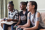 Tween girl friends playing video game in living room