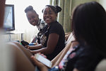 Happy tween girl friends playing video game in living room